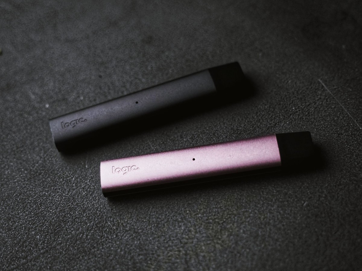 Two slim vape devices side by side on a dark surface Two slim vape devices side by side on a dark surface